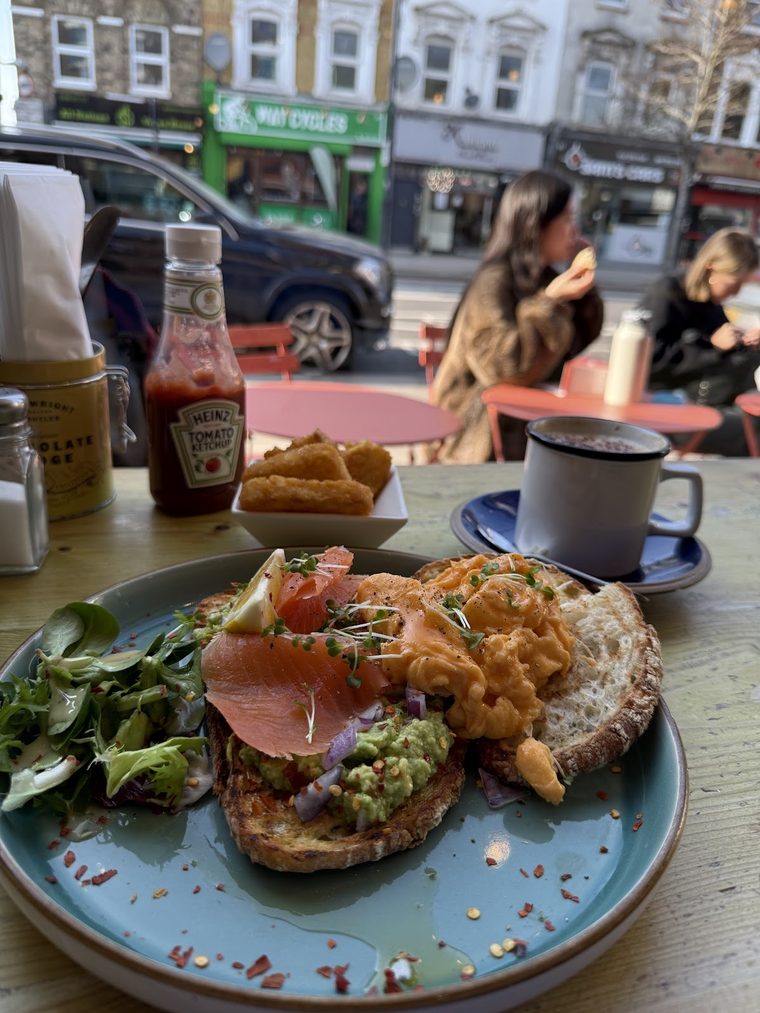 Avocado and salmon toast with salad on a blue plate