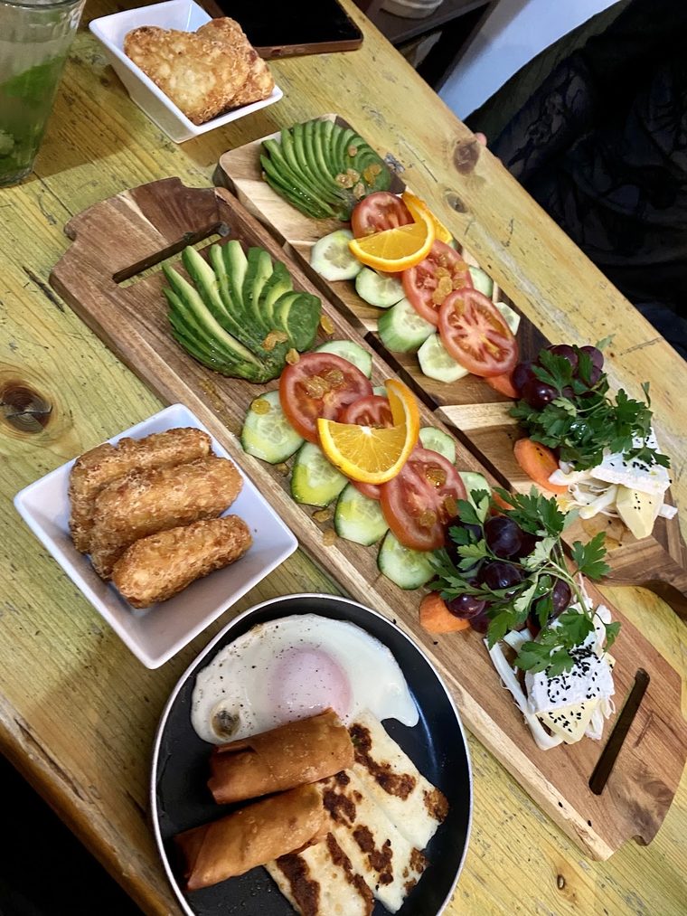 A big sharing breakfast board with a pan of eggs